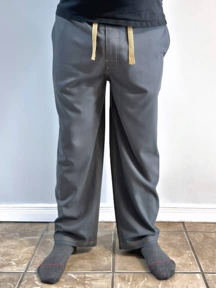 Front view of Daniel Menjívar wearing a pair of freshly sewn grey lounge pants with gold topstitching.